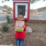 little_girl_holding_up_book