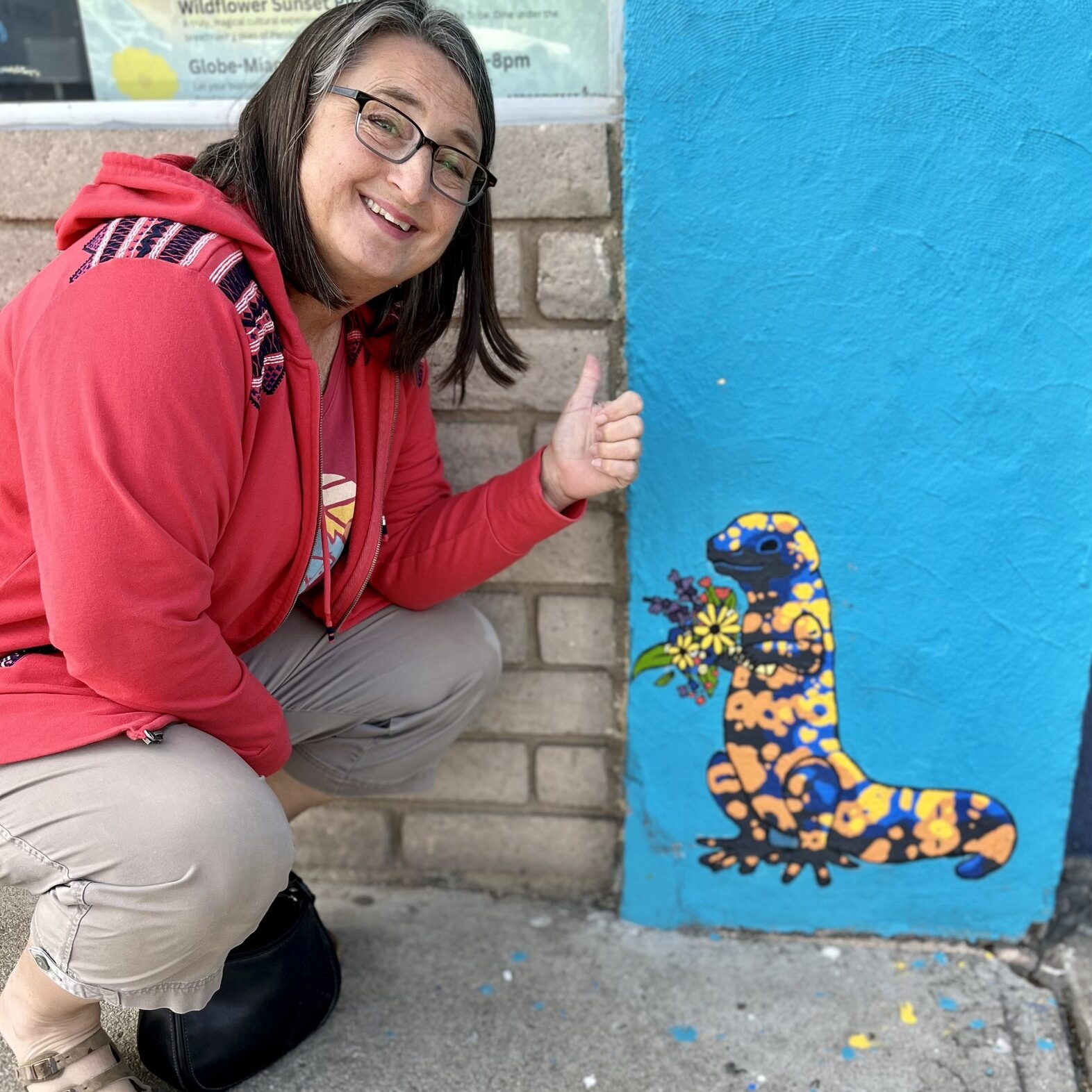 Woman posing next to wall art